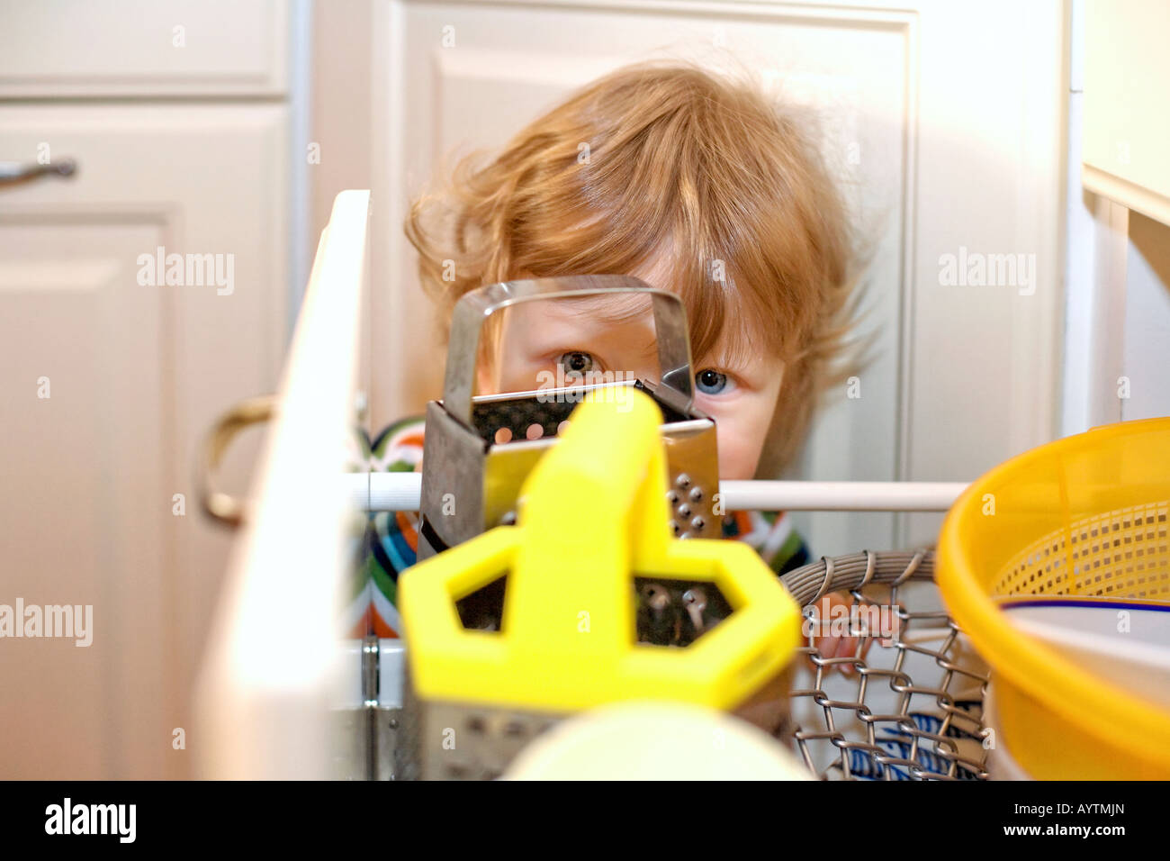 Garçon OUVERTURE TIROIR DANS LA CUISINE Banque D'Images