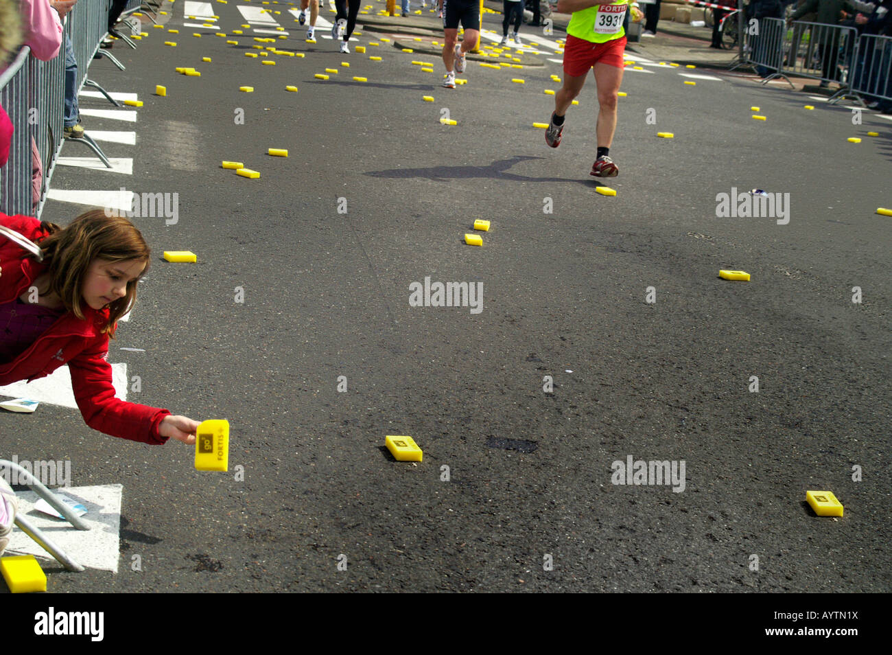 Girl picking éponge rafraîchir jaune à Rotterdam ville rue de marathon race 13 avril 2008 Pays-Bas Banque D'Images