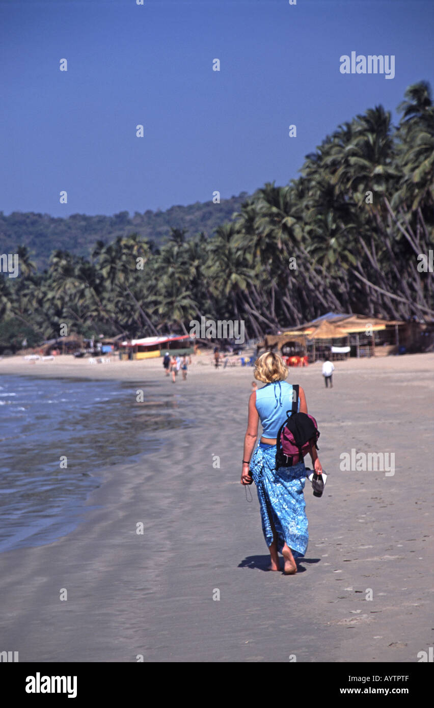 GOA, Inde. Une jeune femme marchant le long de plage de Palolem dans le sud de Goa. Banque D'Images