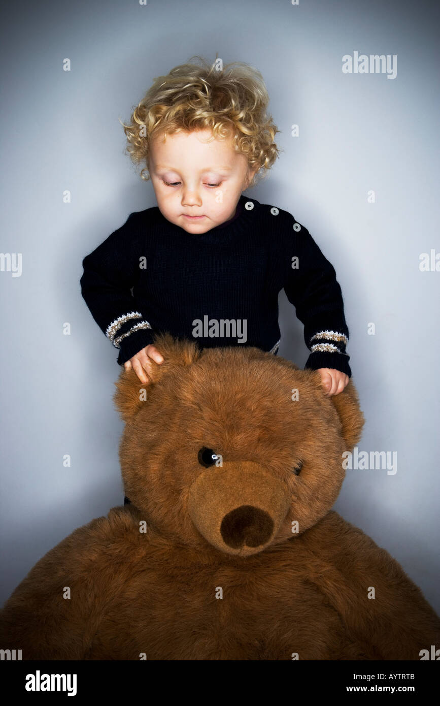 Jeune garçon avec l'ours en peluche géant. Banque D'Images