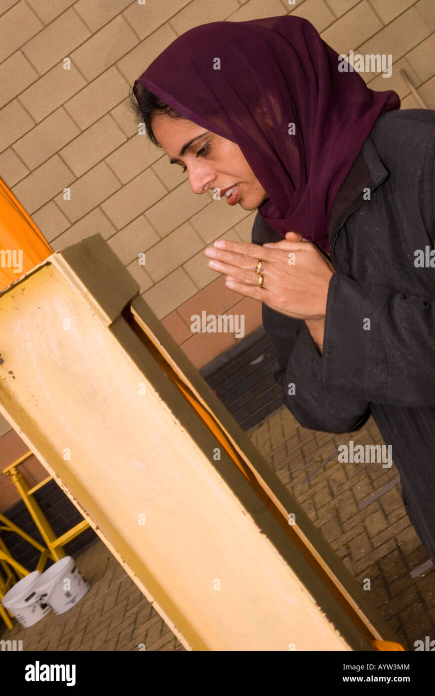 Jeune femme sikh adorant le Nishan Sahib hampe pendant le Vaisakhi Sri Guru Singh Sabha Hounslow Middlesex UK 14 avril 2008 Banque D'Images