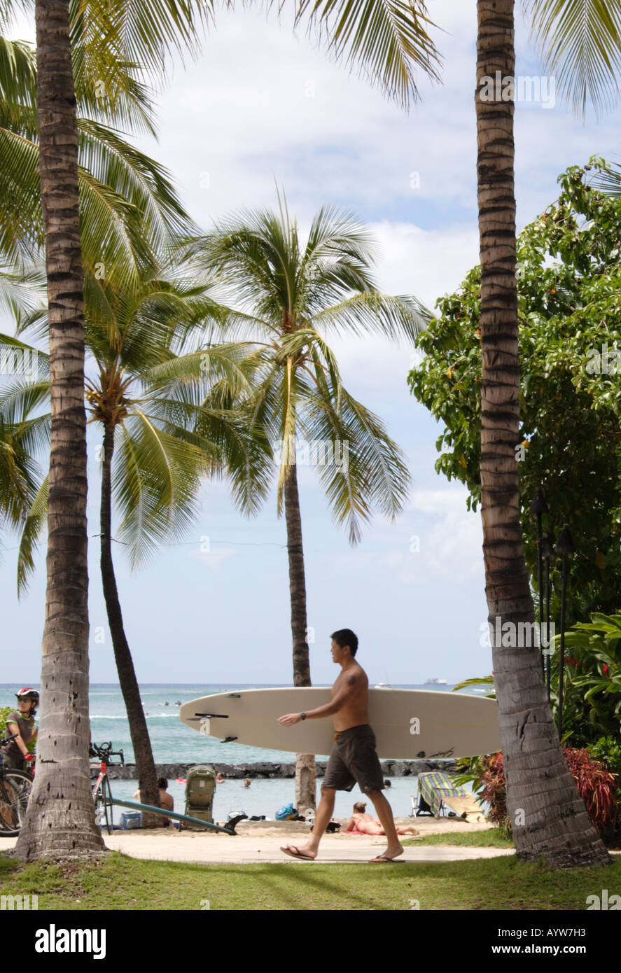 Man Walking with surfboard at Waikiki Beach Banque D'Images