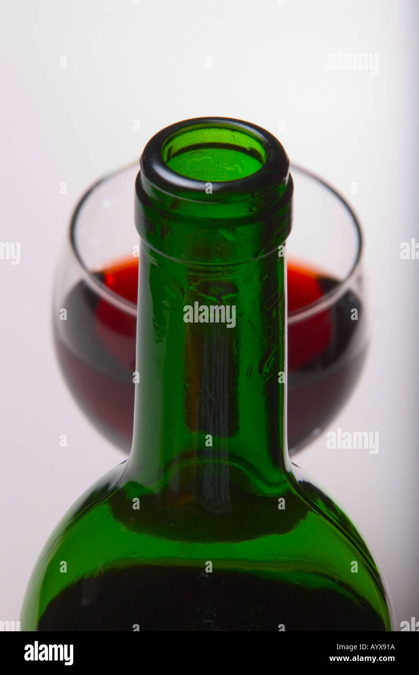 Bouteille de vin vert en premier plan avec gobelet de vin rouge en arrière-plan on white Banque D'Images