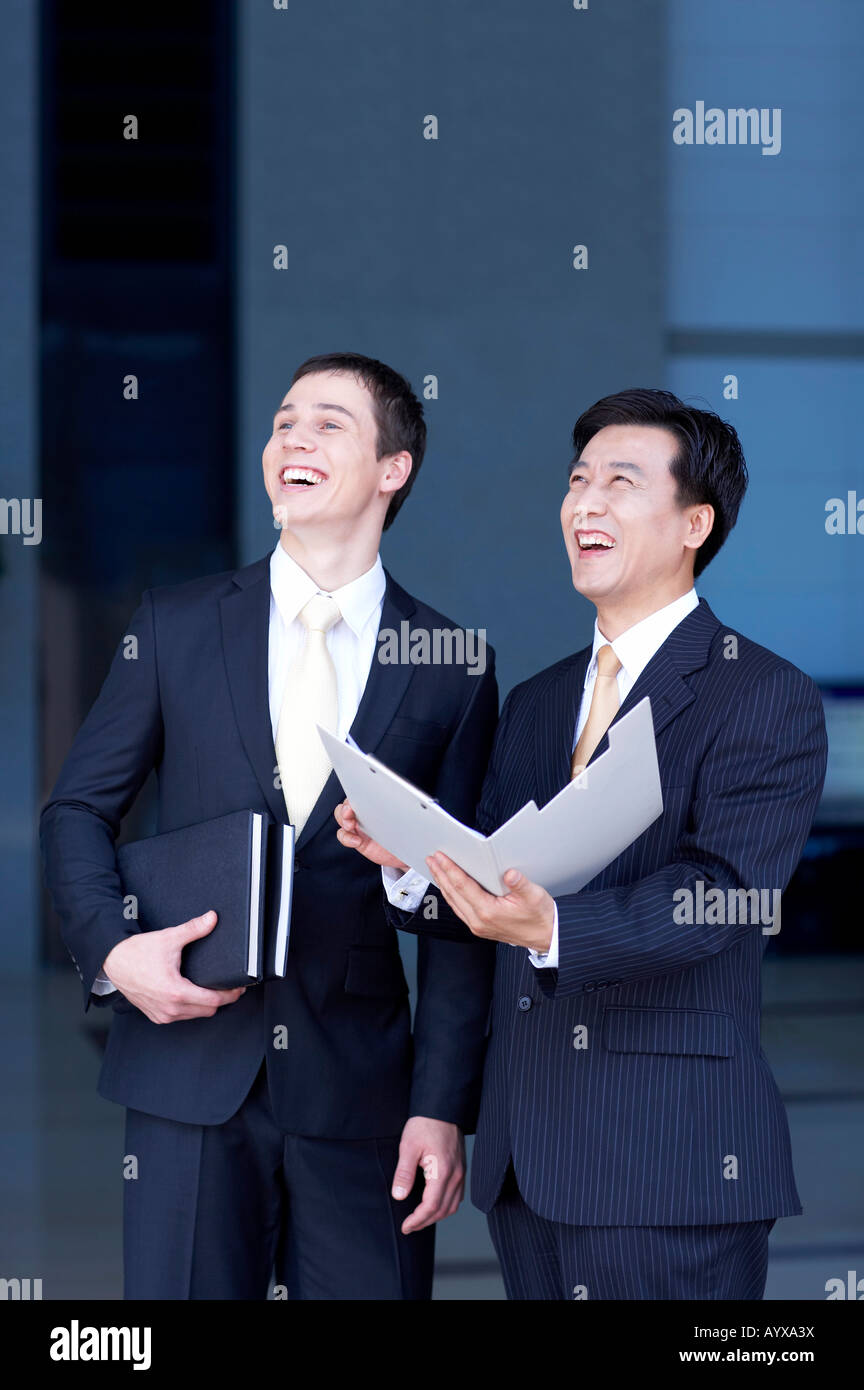 Smiling man with document file à la recherche au même endroit Banque D'Images