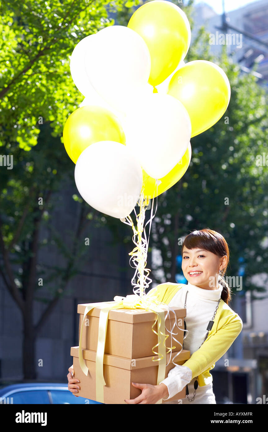 Une femme tenant fort qui est pendu avec balloon Banque D'Images