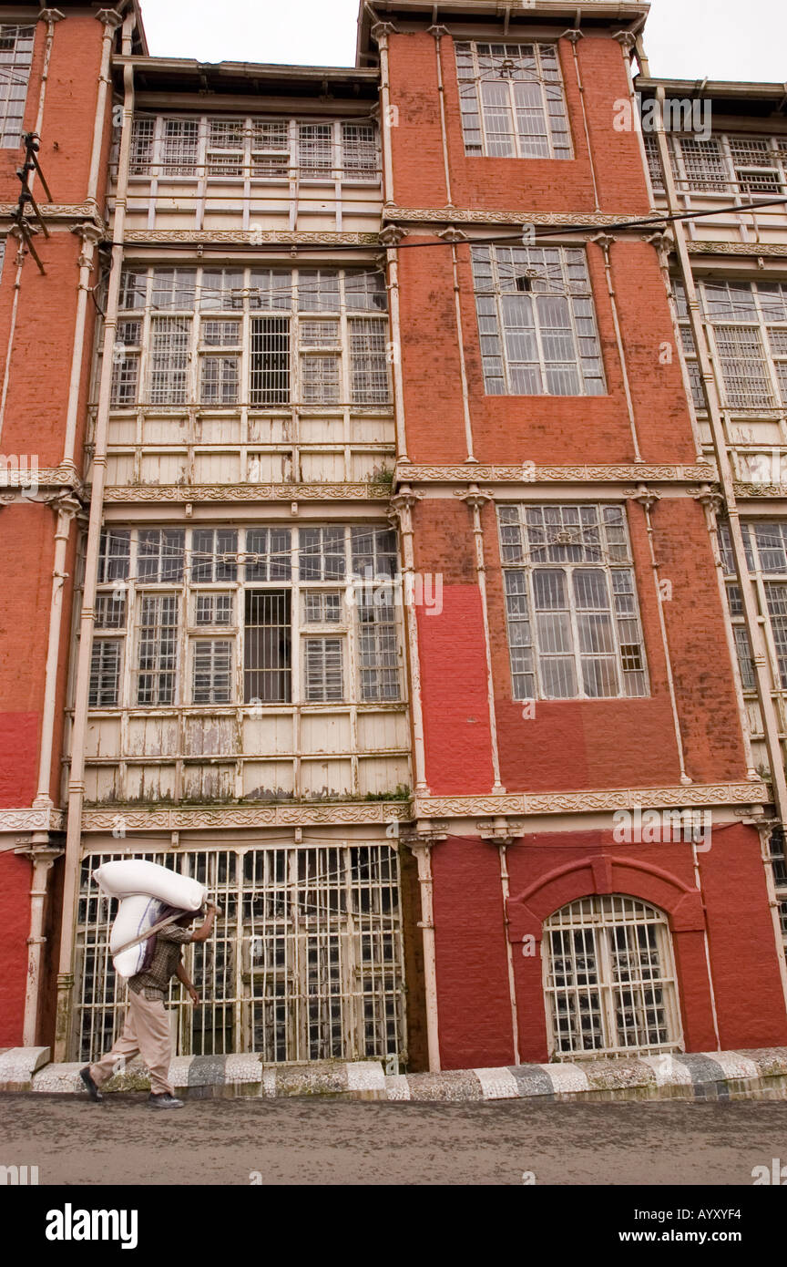 Un portier indien transportant une charge lourde en face de Shimla heritage période britannique Bâtiment Conseil fer 189697 Himachal Pradesh Banque D'Images