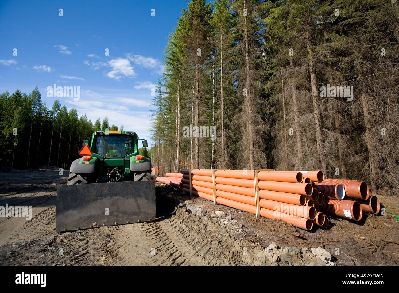 Tracteur et tuyaux de drainage sur le chantier routier à la campagne, Finlande Banque D'Images