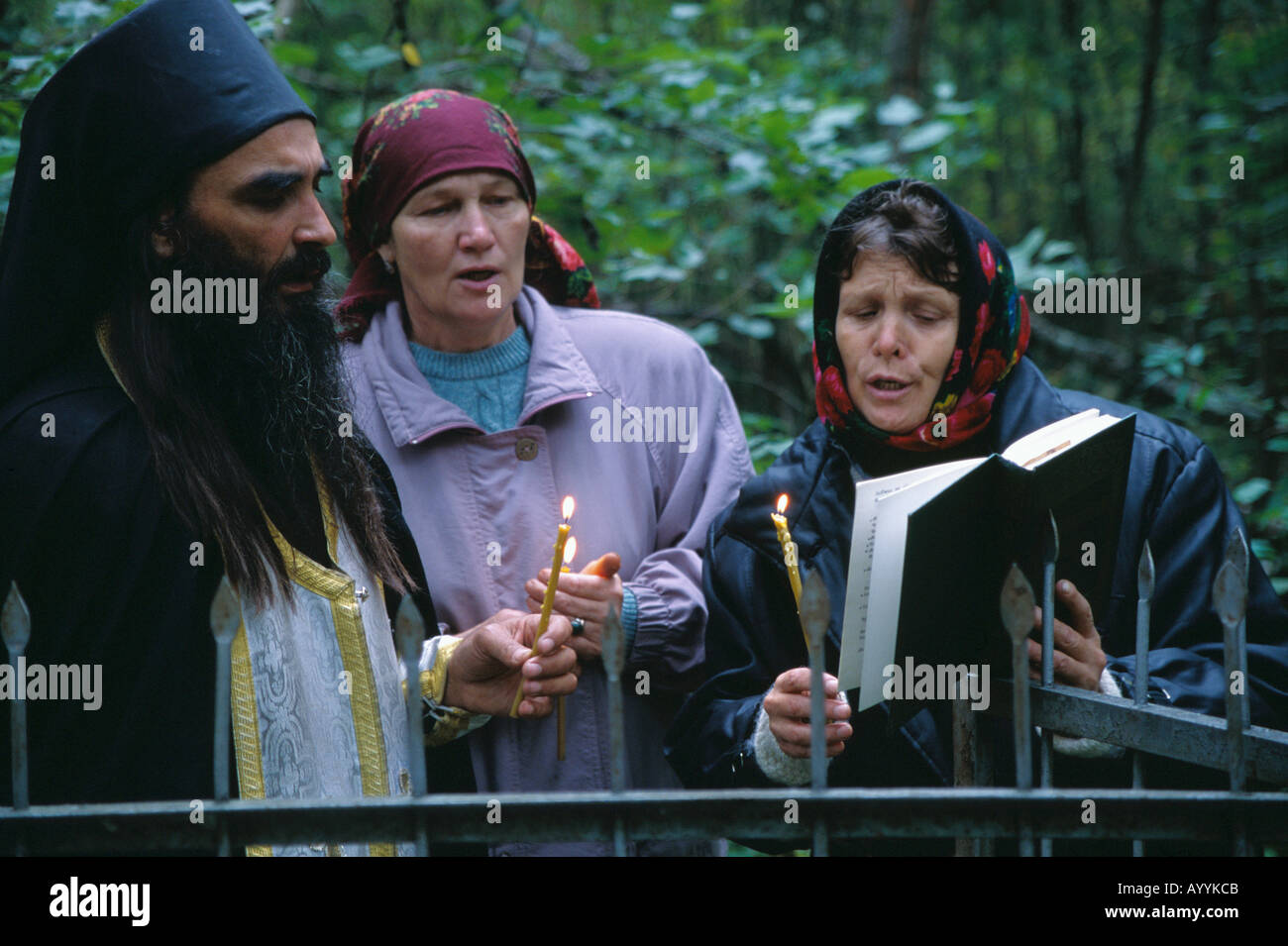 La Russie, Kostroma district,un prêtre orthodoxe russe effectuer un service religieux dans un cimetière de la forêt un an après la mort Banque D'Images