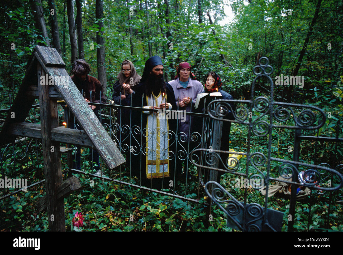 La Russie, Kostroma district,un prêtre orthodoxe russe effectuer un service religieux dans un cimetière de la forêt un an après la mort Banque D'Images