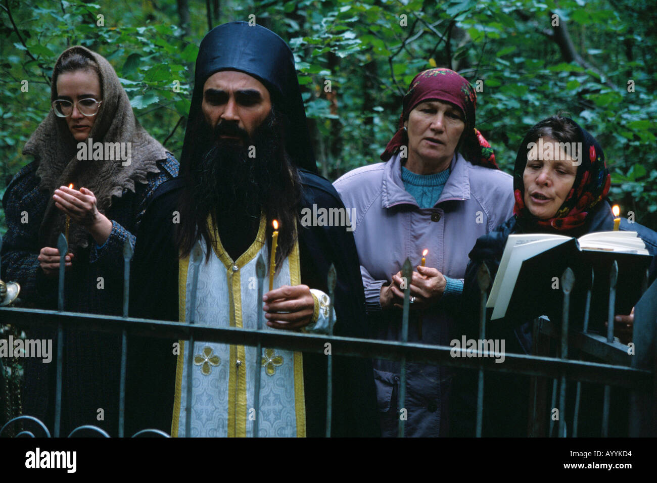 La Russie, Kostroma district,un prêtre orthodoxe russe effectuer un service religieux dans un cimetière de la forêt un an après la mort Banque D'Images