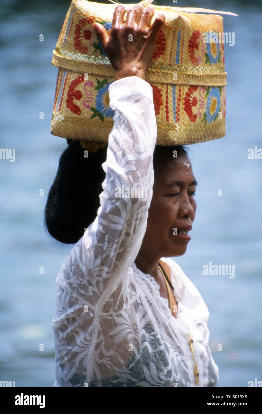 Adorateur balinais portant son panier prier revient de l'autre côté de l'île après la visite de Tanah Lot Temple Bali Indonesia Banque D'Images