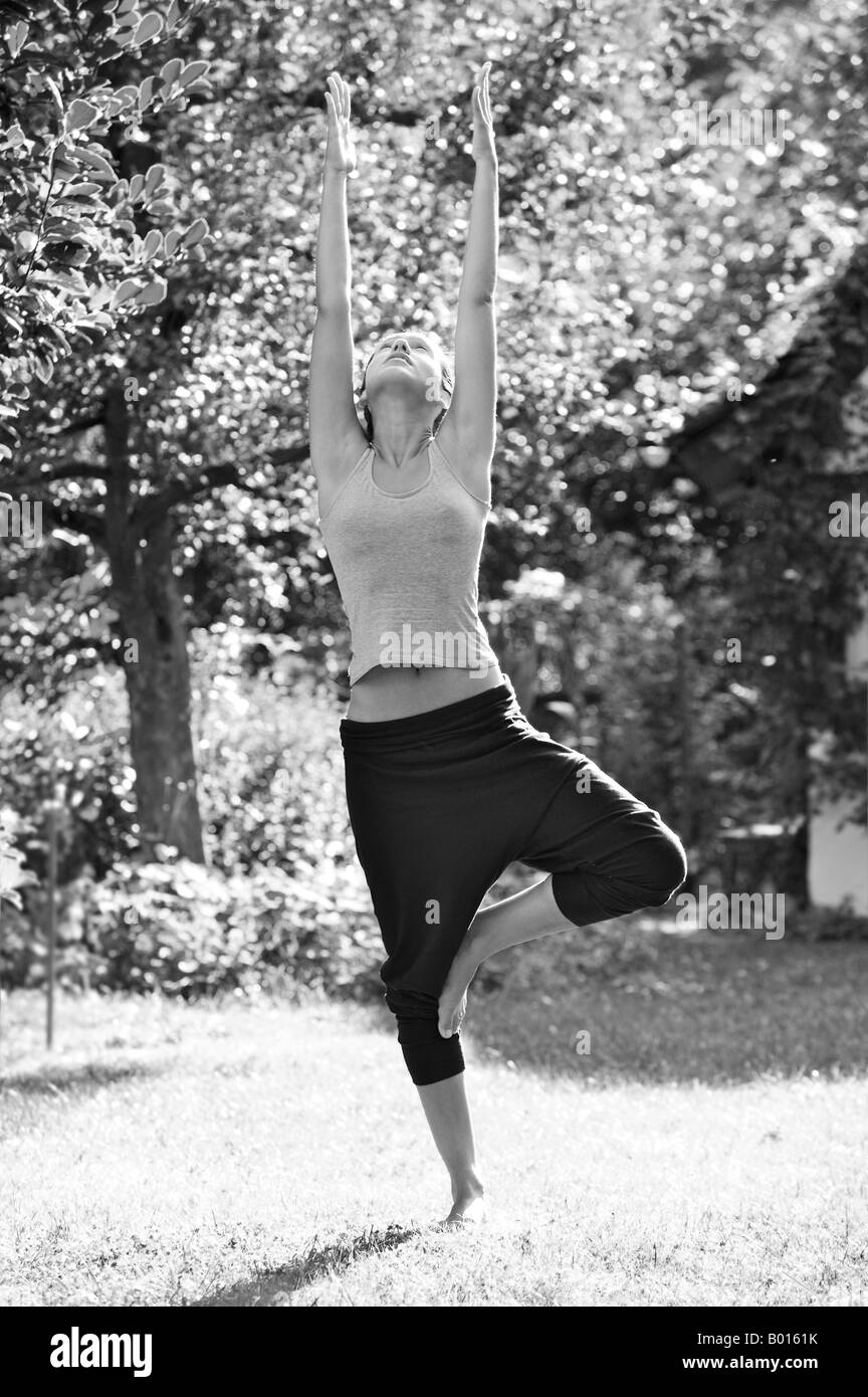 Femme practizing Yoga dans un jardin Banque D'Images