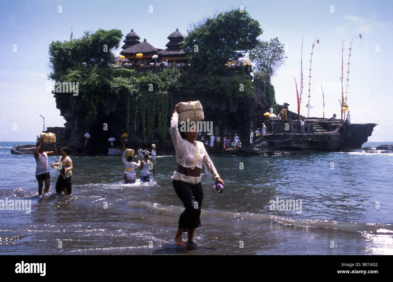 Adorateur balinais portant son panier prier revient de l'autre côté de l'île après la visite de Tanah Lot Temple Bali Indonesia Banque D'Images