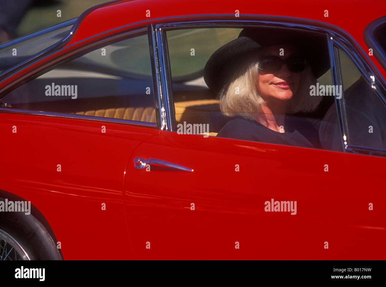 Dame en lunettes de soleil dans une voiture de sport italienne classique Banque D'Images