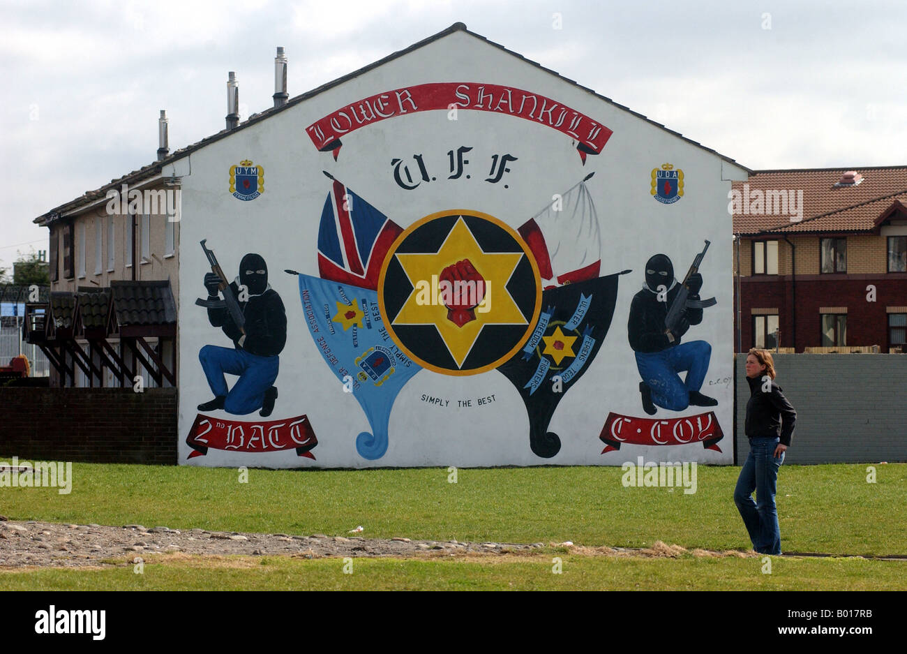 Une femme passe devant une peinture murale loyalistes protestants à Belfast. Banque D'Images