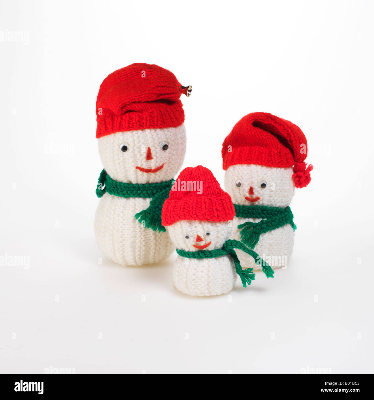 3 knit bonhommes de famille avec des bonnets rouges et verts foulards Banque D'Images