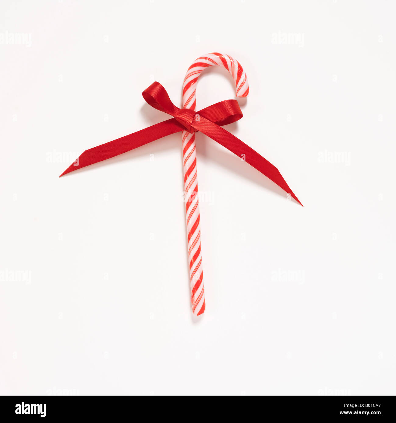 Canne de Noël avec arc ruban rouge sur fond blanc Banque D'Images