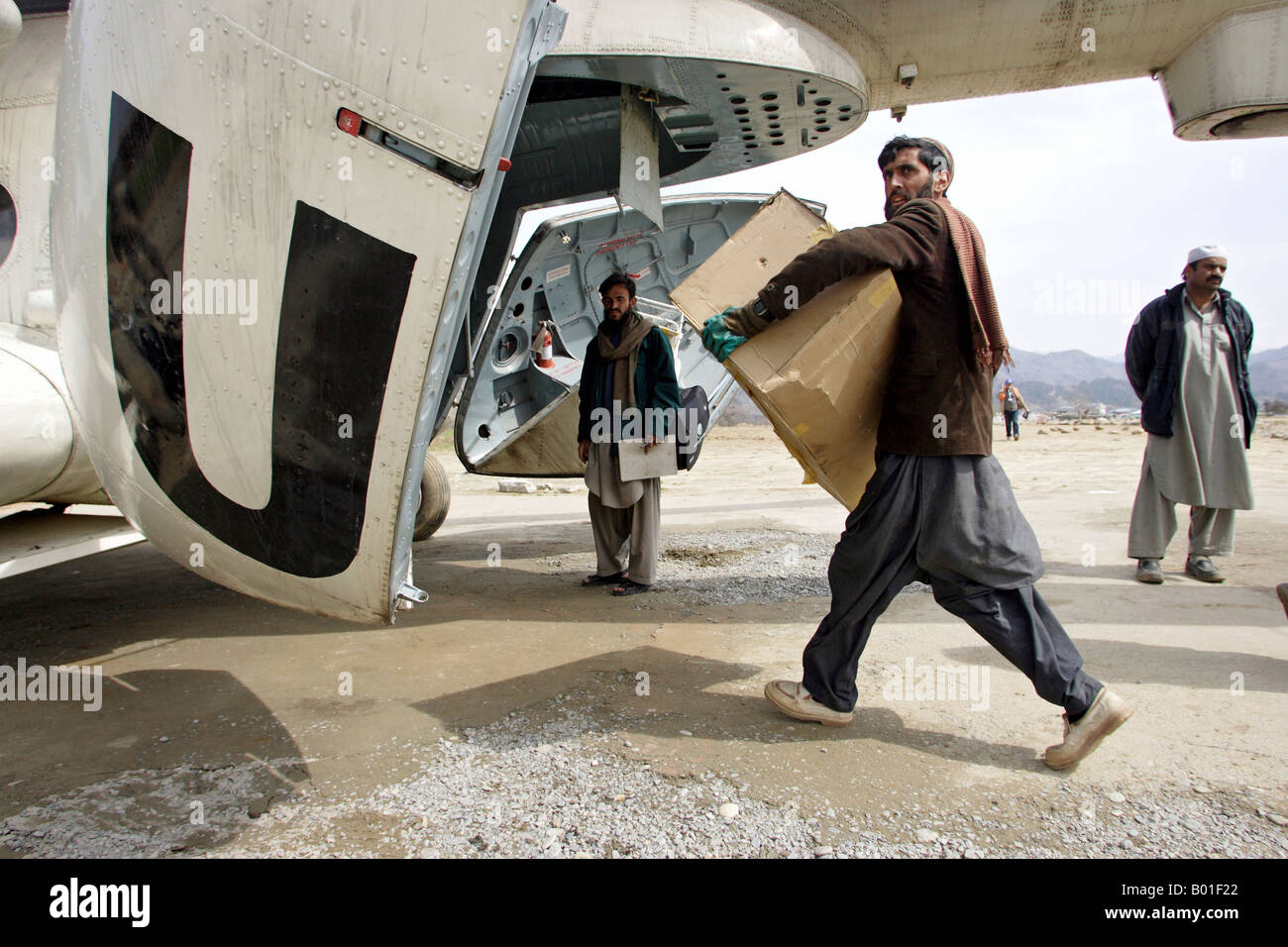 Les travailleurs de secours d'un hélicoptère des Nations Unies avec un chargement de fournitures d'aide aux victimes du séisme, Chattar, Plaine Pakistan Banque D'Images