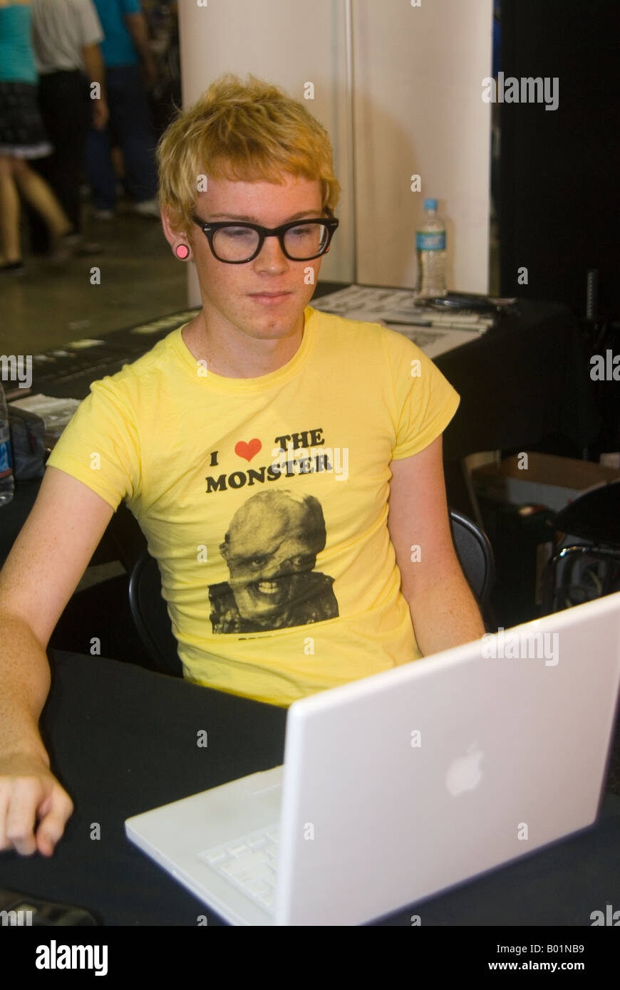 Geek à un ordinateur portable Mac 'J'aime le monstre' T shirt Banque D'Images