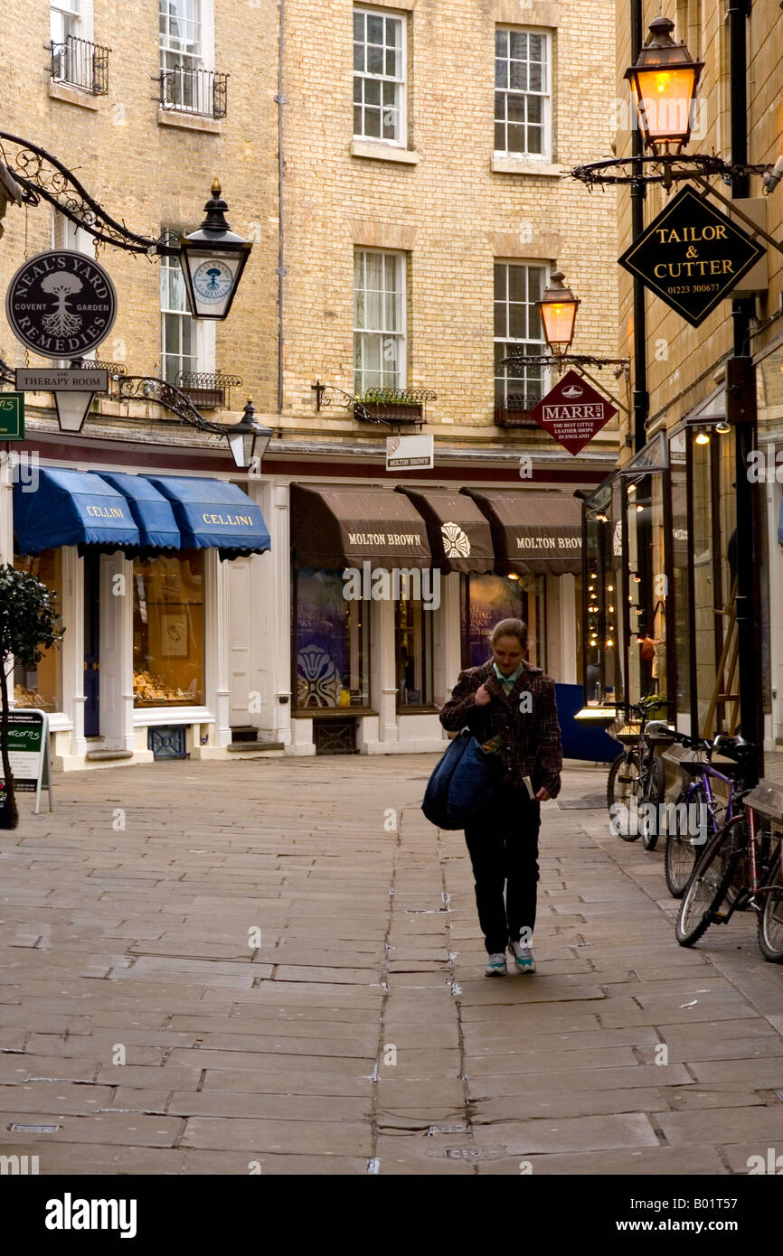 Une jeune femme en passant devant des boutiques à la mode dans Rose Crescent, Cambridge, Cambridgeshire, East Anglia, Angleterre, RU Banque D'Images