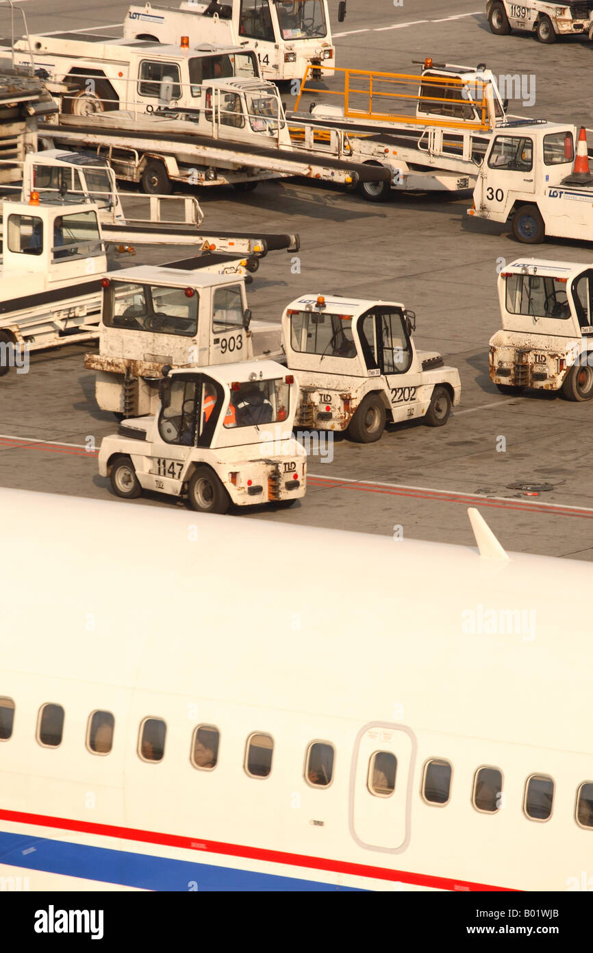 Avion de ligne à l'aéroport services au sol et l'avion remorqueur tracteur chariot à bagages des véhicules Banque D'Images