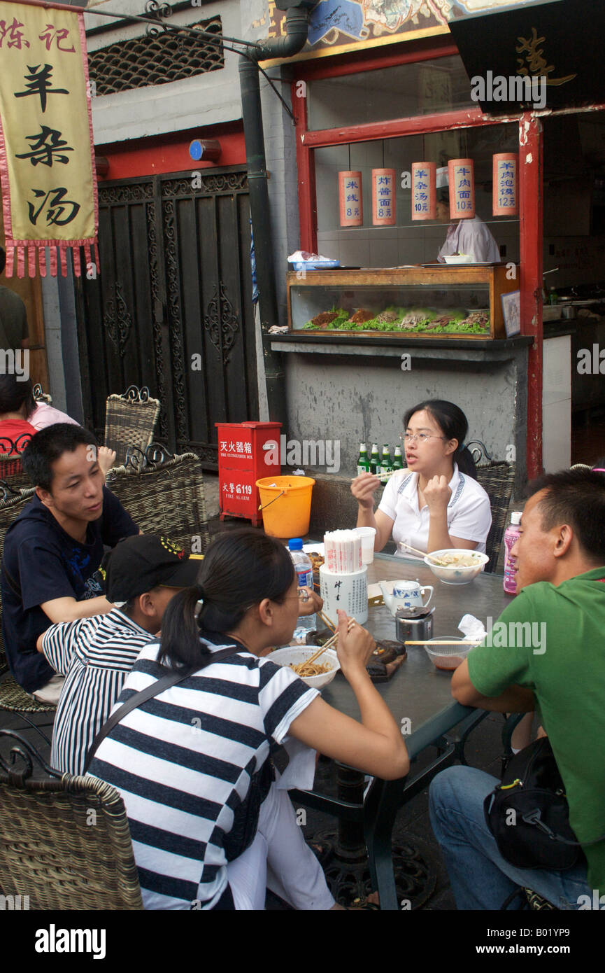Une famille prenez un délicieux repas dans la rue Wangfujing snack street, Beijing Chine Banque D'Images