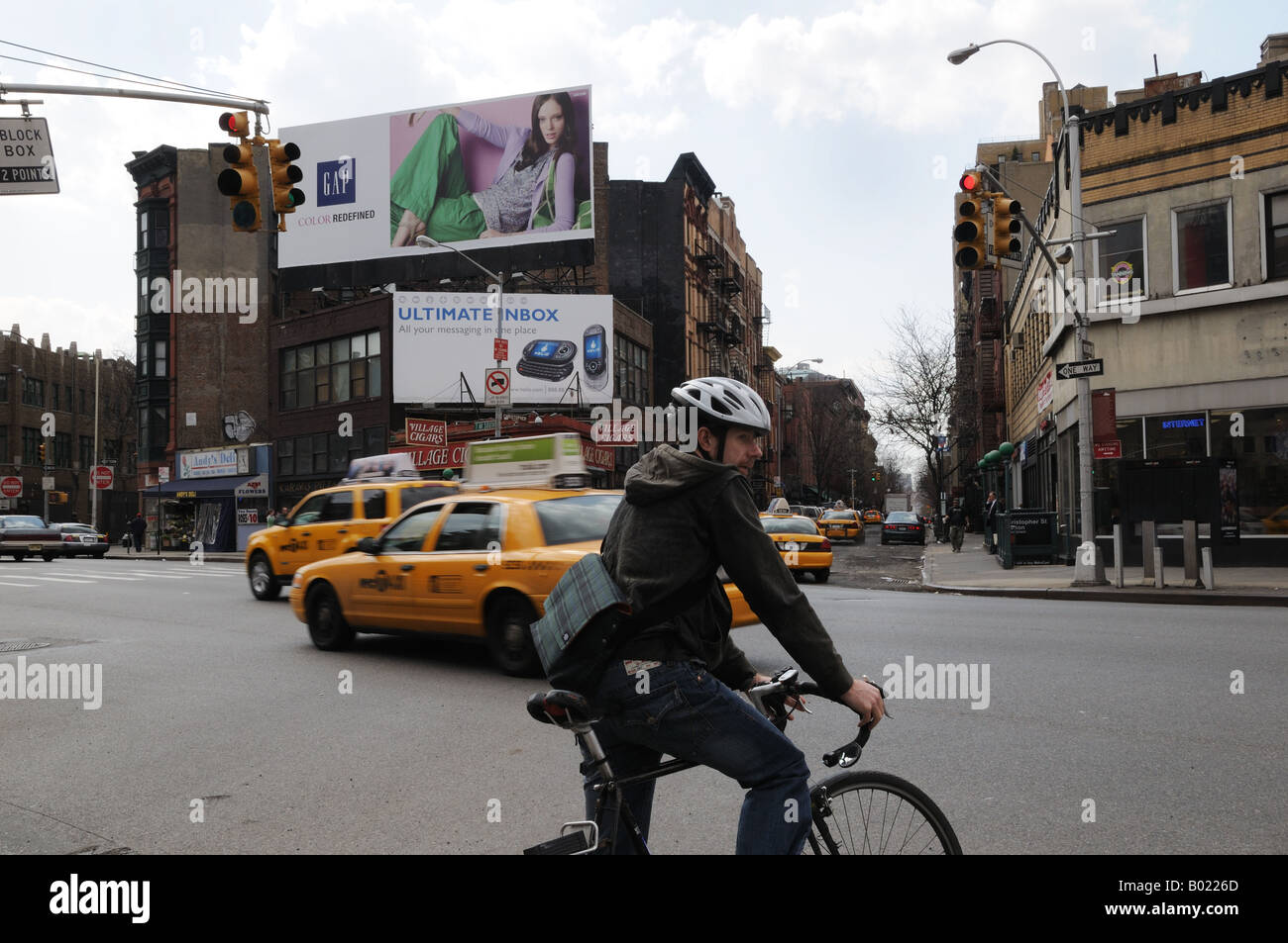 Un vélo messenger attend que le feu passe au Christopher Street et 7e Avenue à Manhattan, dans le Greenwich Village. Banque D'Images