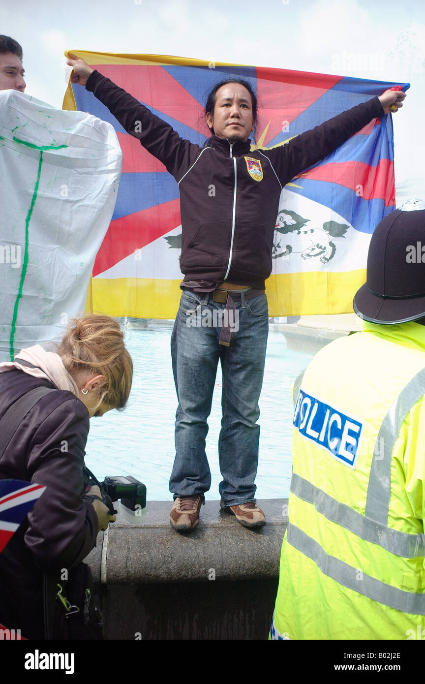 Un manifestant brandissant un drapeau tibétain à Trafalgar Square London Banque D'Images