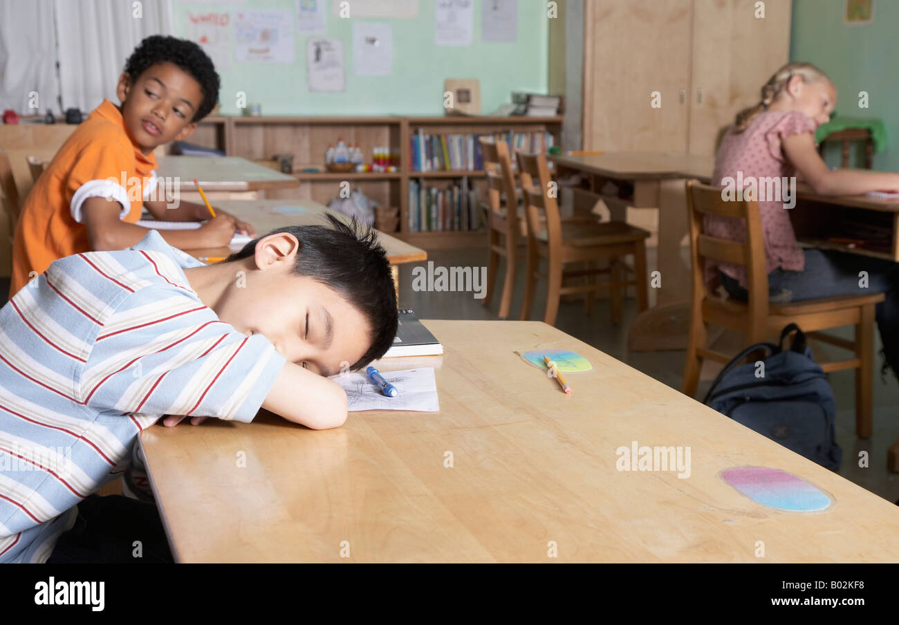 Asian boy sleeping in classroom Banque D'Images