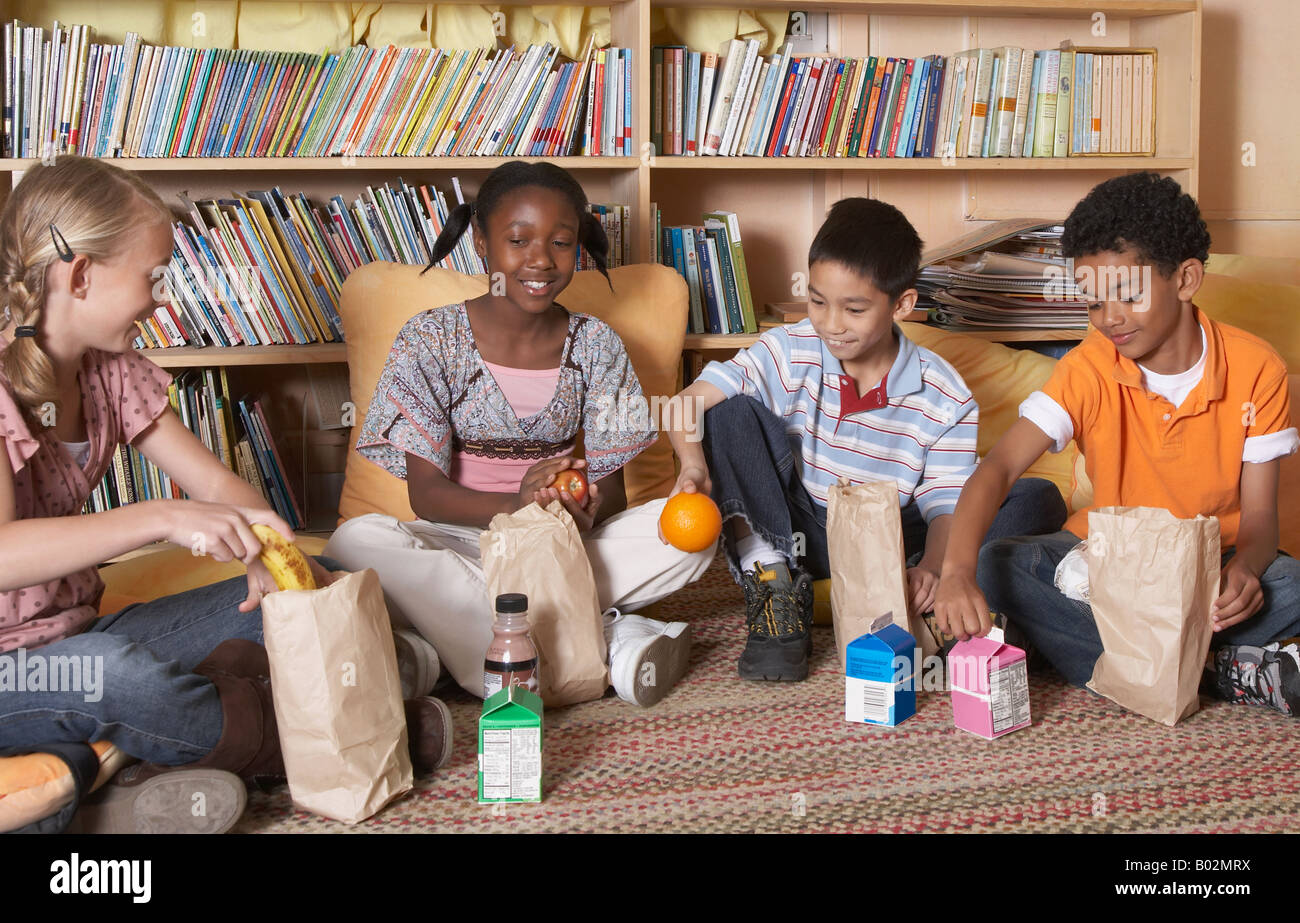 Les enfants de l'école multi-ethnique de manger le déjeuner Banque D'Images