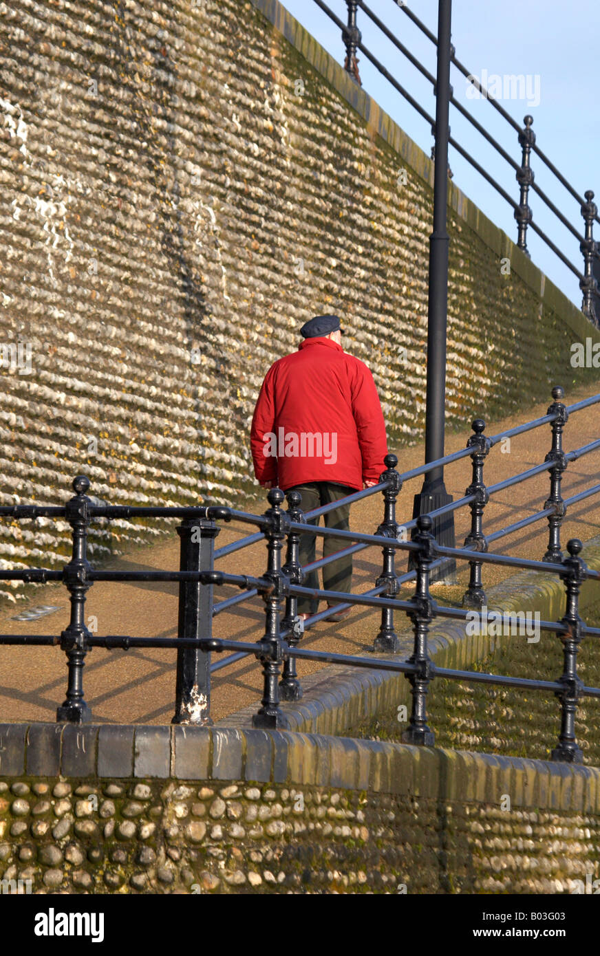 Un homme âgé à monter une pente vers le haut de la falaise à Cromer sur la côte de Norfolk Banque D'Images