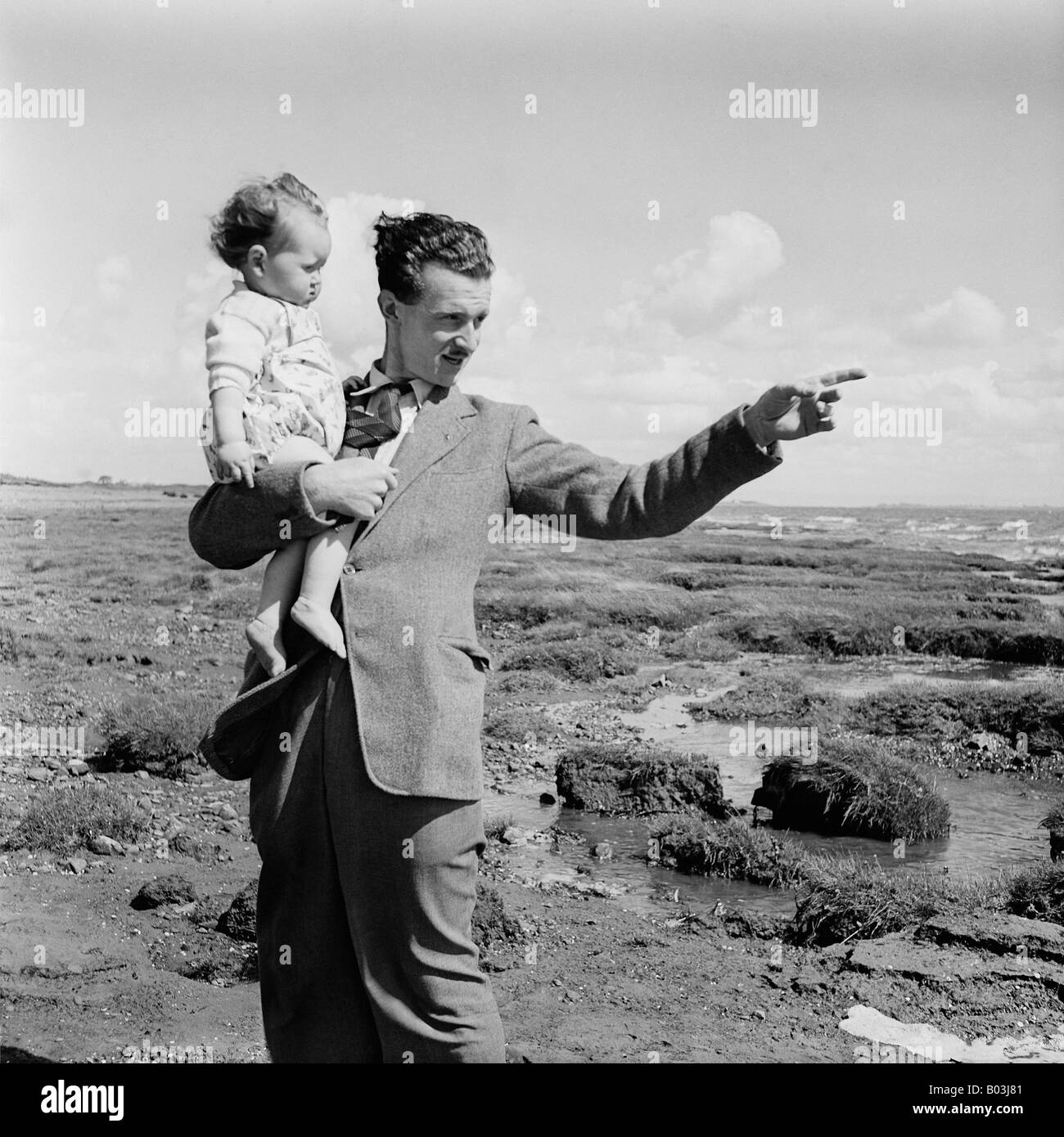 OLD VINTAGE SNAPSHOT FAMILLE PHOTOGRAPHIE DE MAN HOLDING BABY GIRL ET EN POINTANT AVEC LE DOIGT EN DISTANCE Banque D'Images