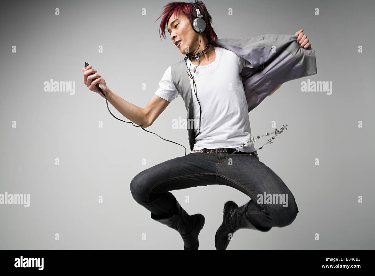 Japanese man listening to mp3 player Banque D'Images
