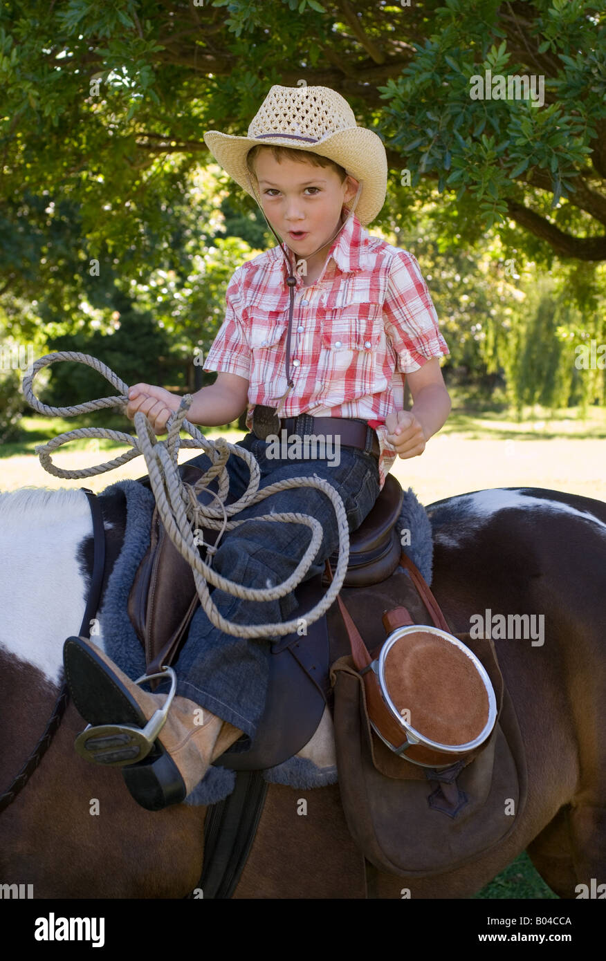 Un garçon à cheval et tenant un lasso Banque D'Images