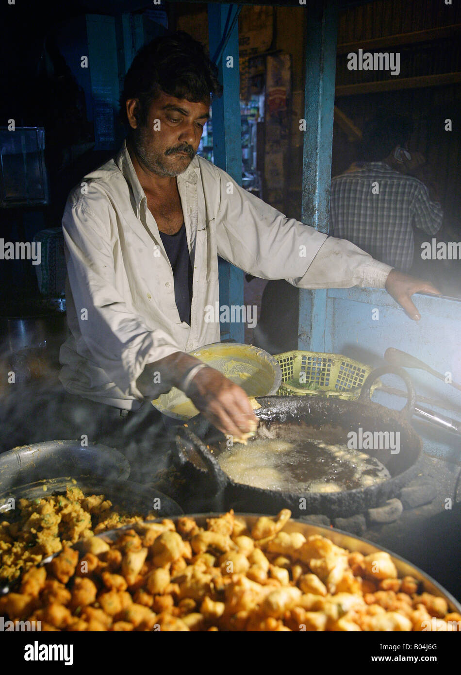 Vendeur de rue, rendant les aliments frits épicés Banque D'Images