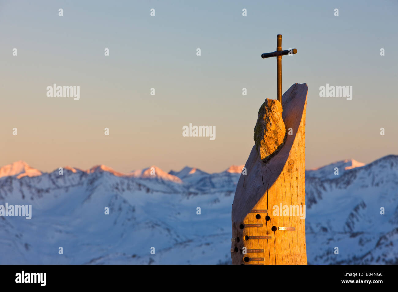 Croix sur le balcon du restaurant au domaine de ski Wildkogel backdropped par les montagnes aux sommets enneigés de l'Hohe Tauern Banque D'Images