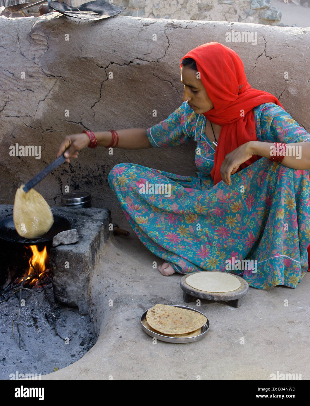 Femme Village chapati de cuisson sur un feu ouvert, près de Jodhpur, Rajasthan, India Banque D'Images