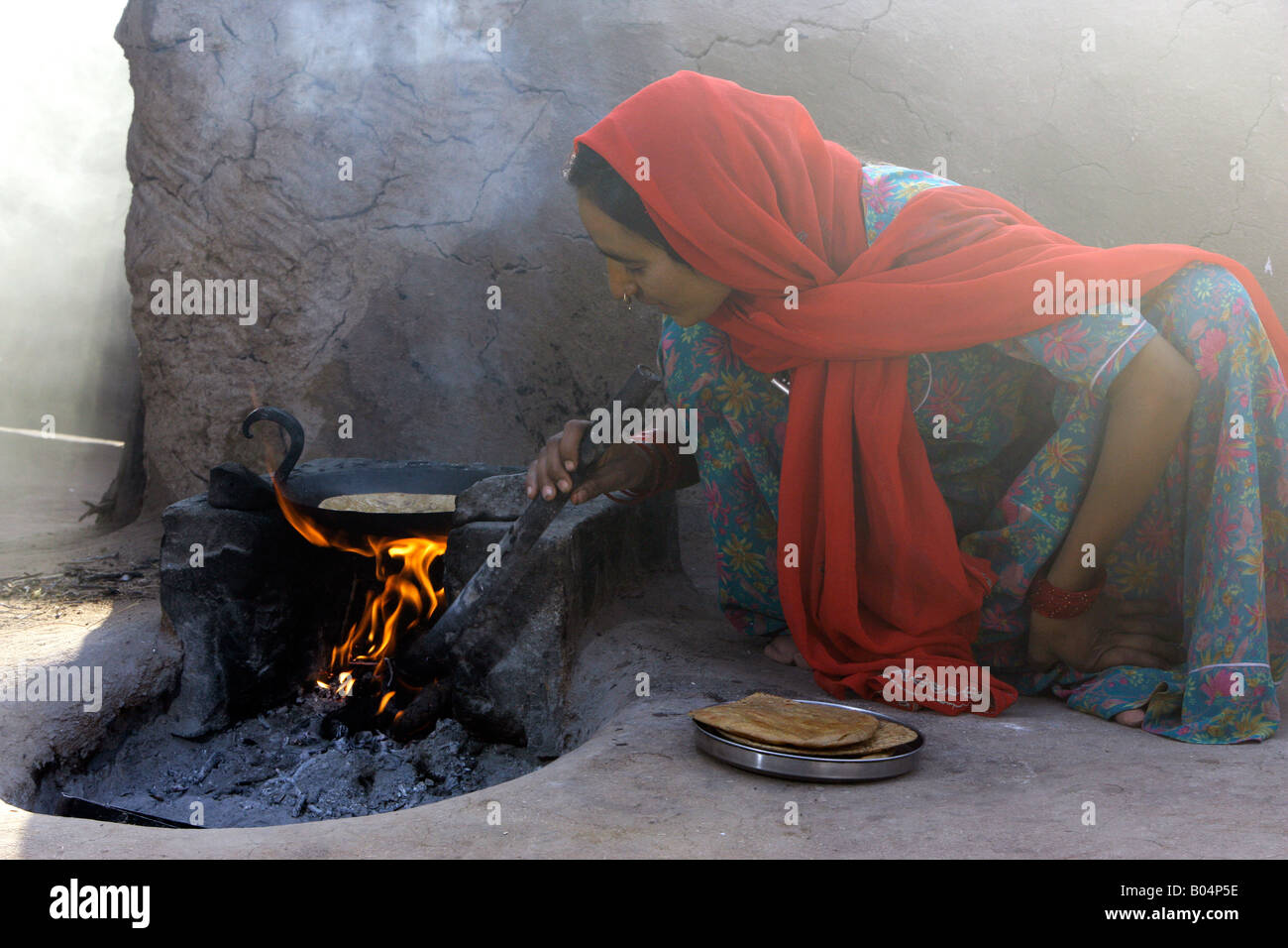 La cuisine femme Village chapati sur feu ouvert, près de Jodhpur, Rajasthan, India Banque D'Images