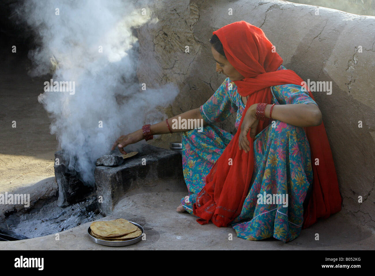 Femme Village chapati de cuisson sur un feu ouvert, près de Jodhpur, Rajasthan, India Banque D'Images