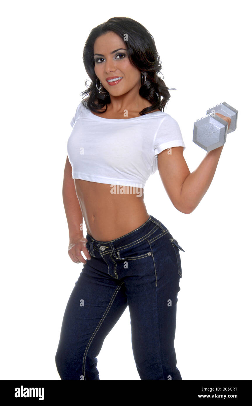 Jeune femme entraîneur personnel de conditionnement physique dans designer jeans et un t-shirt la moitié d'un curling 15 pound dumbell dans sa main gauche Banque D'Images