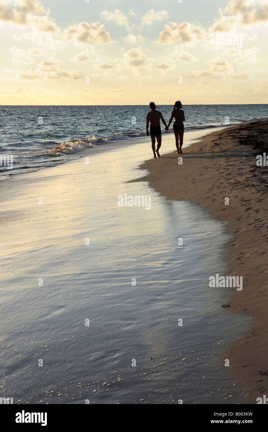 Couple de prendre une marche sur une plage de sable de tropical resort Banque D'Images