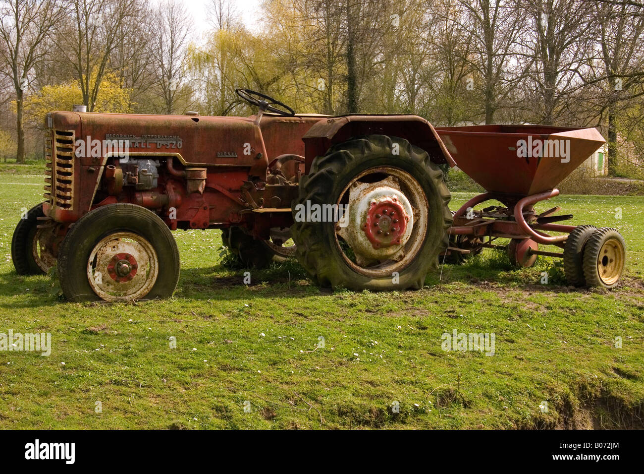 Vieux tracteur rouge sur la terre Banque D'Images