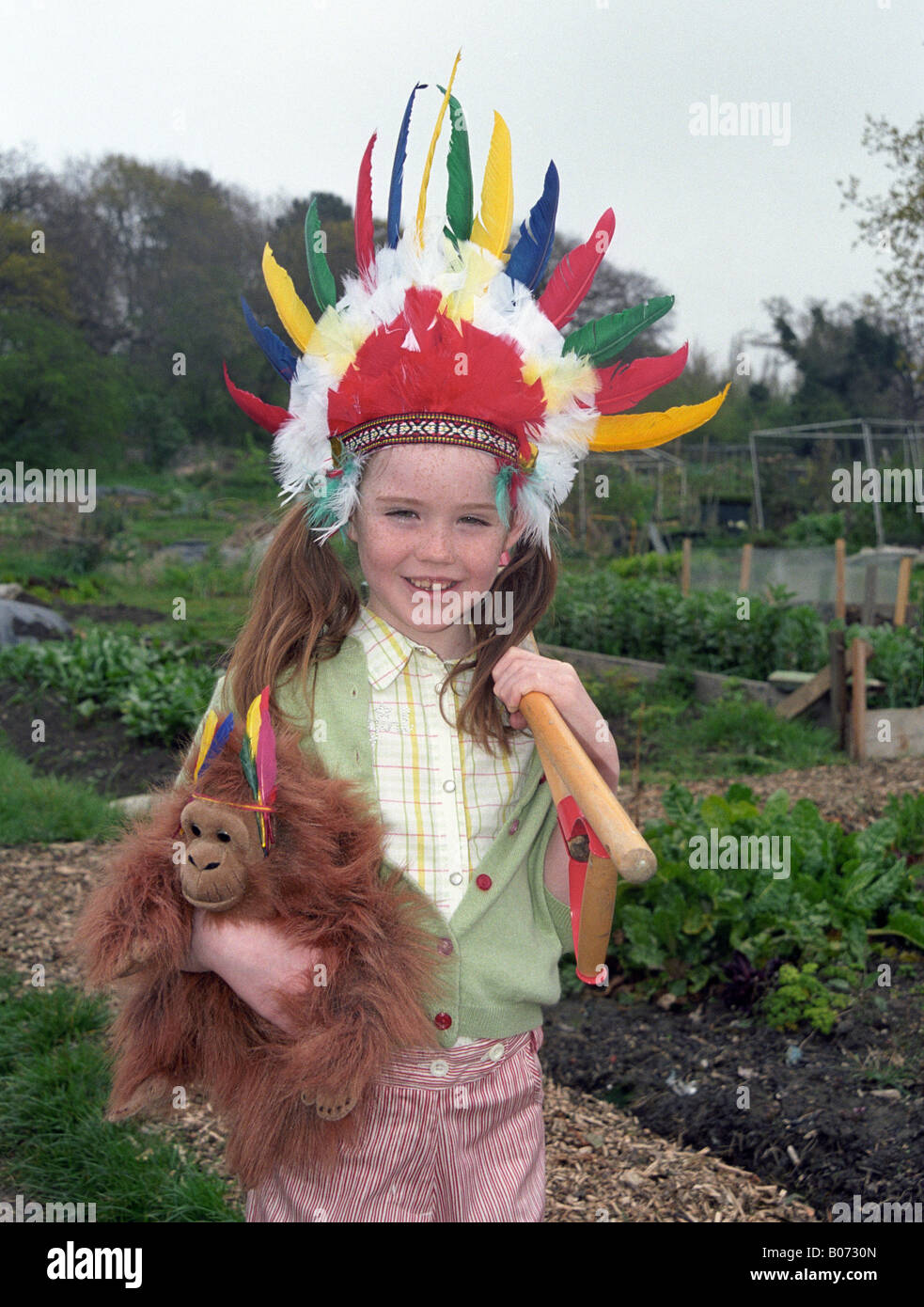 Petite fille dans les affectations avec les outils de jardinage Banque D'Images
