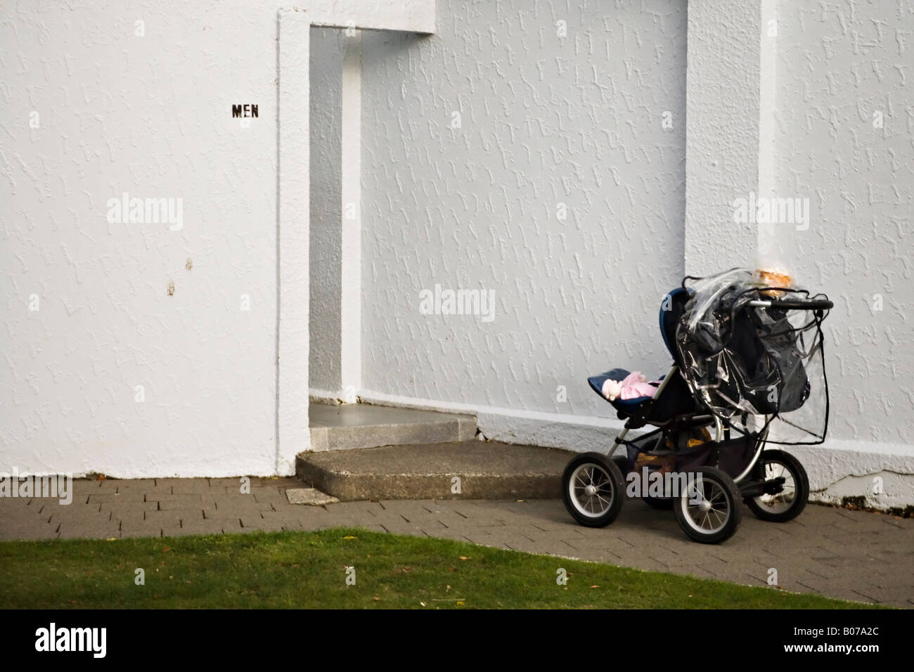 Poussette avec bébé à l'extérieur gauche toilettes pour hommes dans un parc public de la Nouvelle-Zélande Banque D'Images