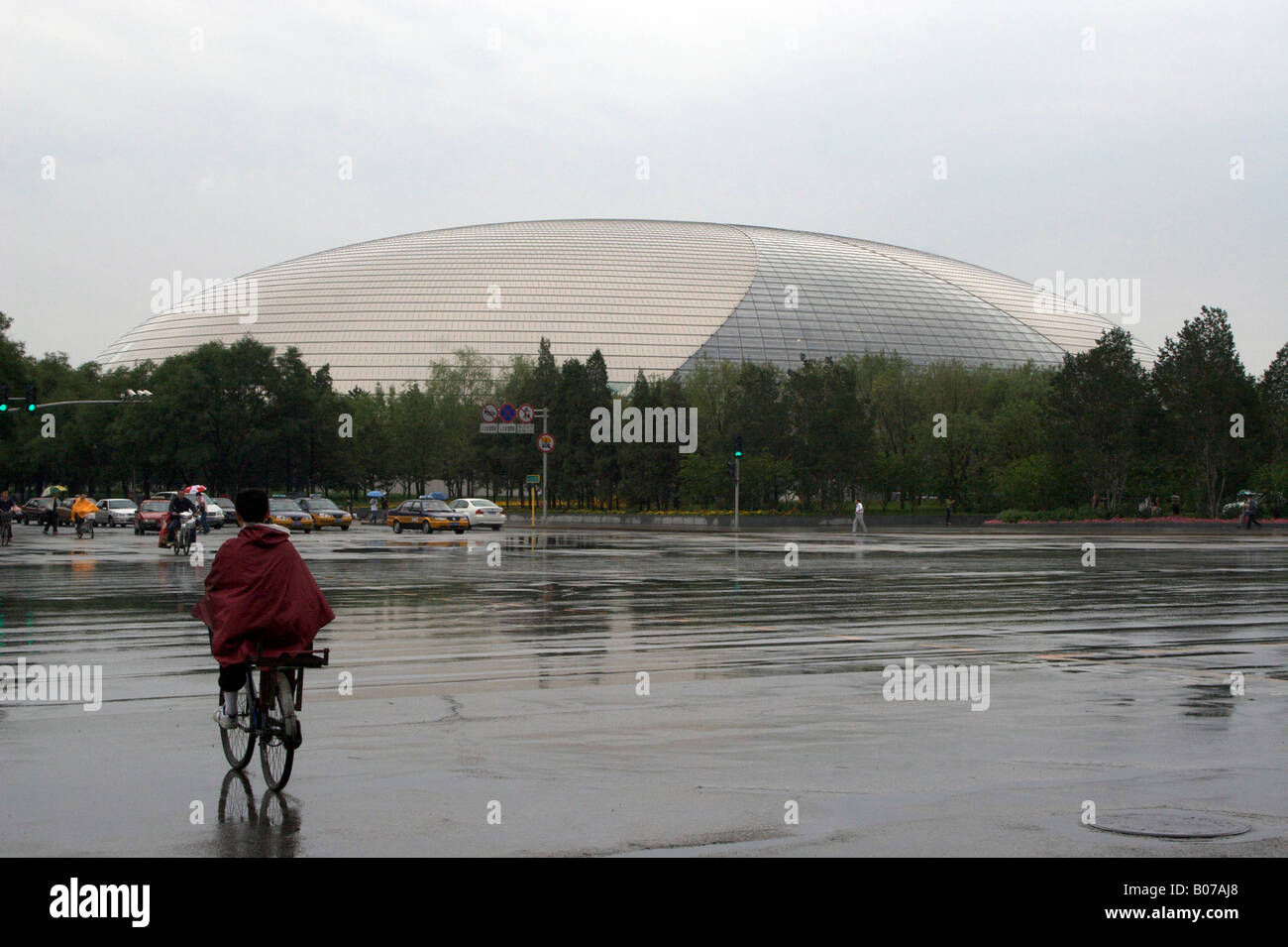 Le dôme Théâtre National avec un cycliste à l'avant-plan Beijing Chine Banque D'Images