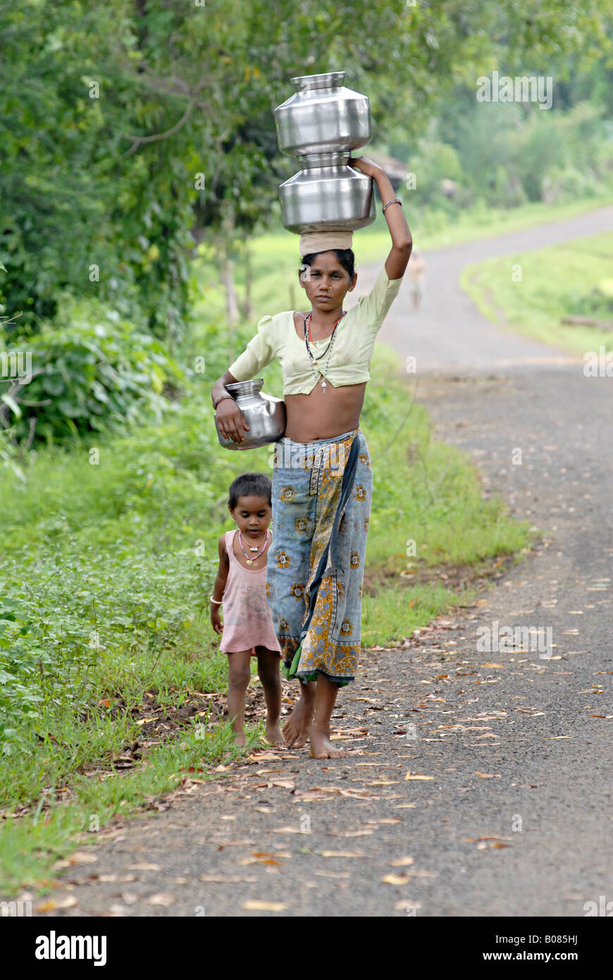Mère avec son enfant pour transporter de l'eau des pots. Tribu Warli, Thane, Maharashtra, Inde Banque D'Images