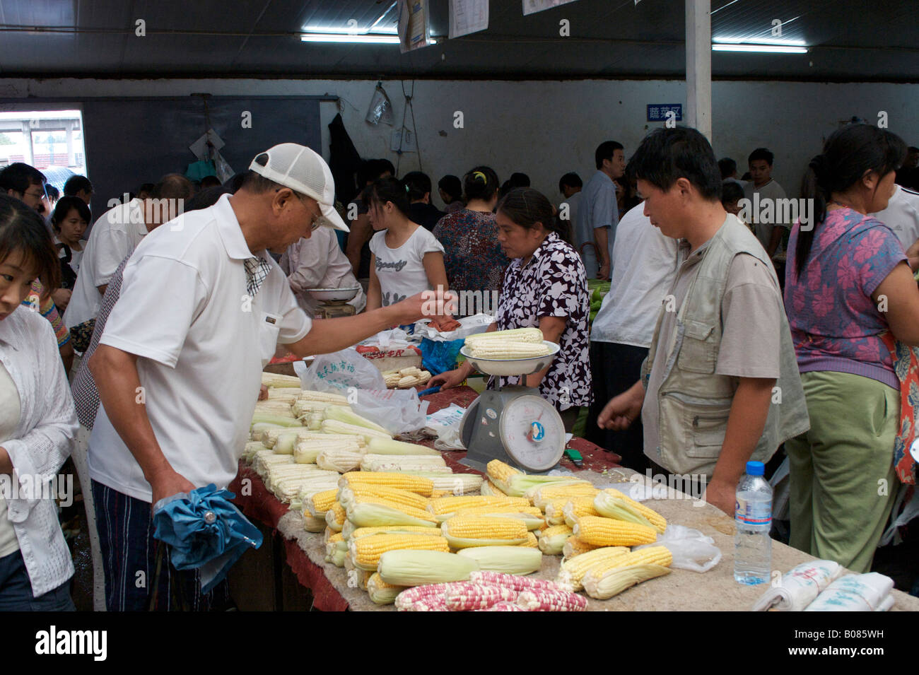 Un homme achète le maïs d'un vendeur de légumes du marché Beijing Chine Banque D'Images