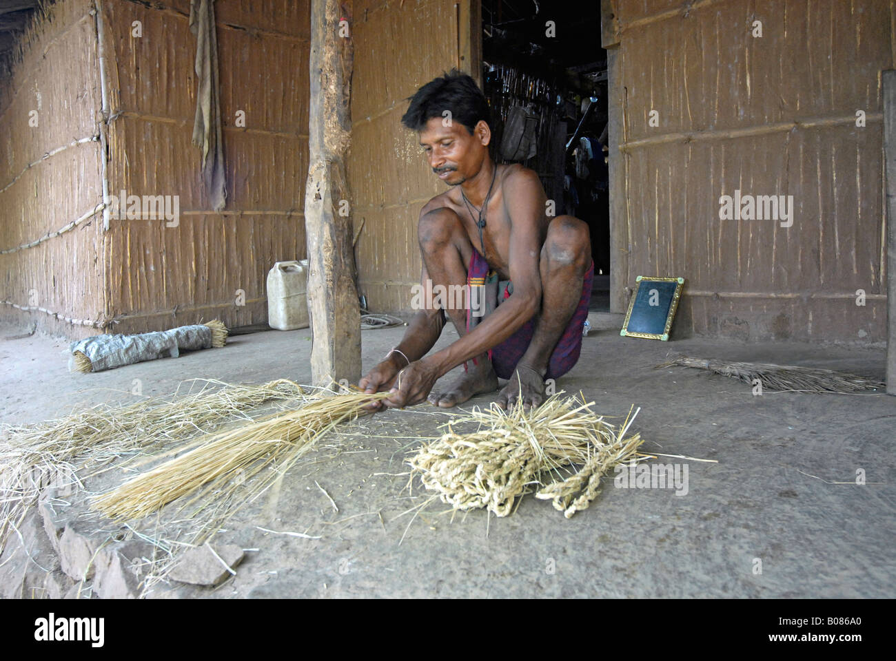Tribal Warli mâle est occupé à la fabrication de cordes. Banque D'Images