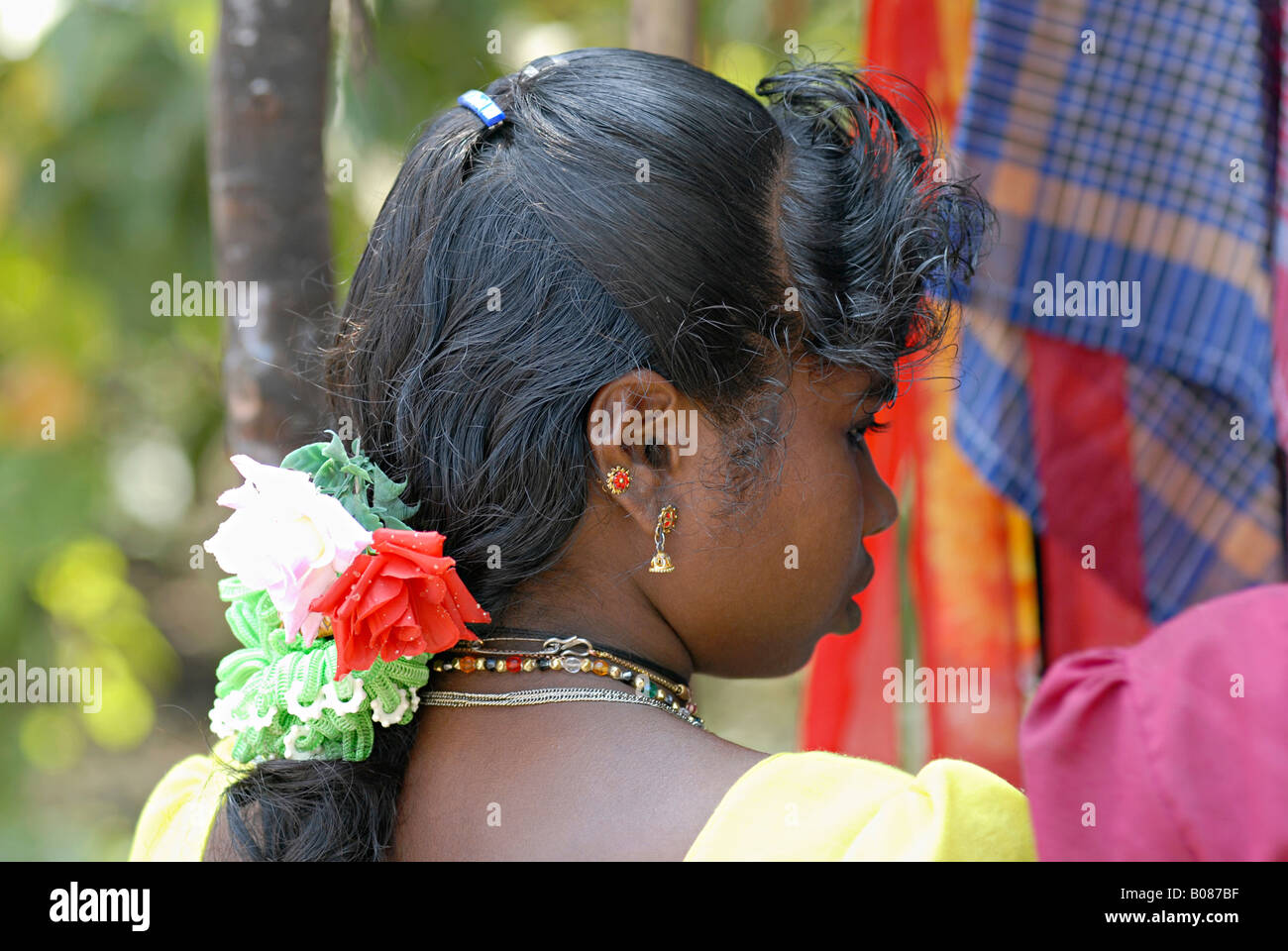 Vue latérale du tribal Warli girl itinérance sur le marché (HASM) fleurs caché dans ses cheveux Banque D'Images