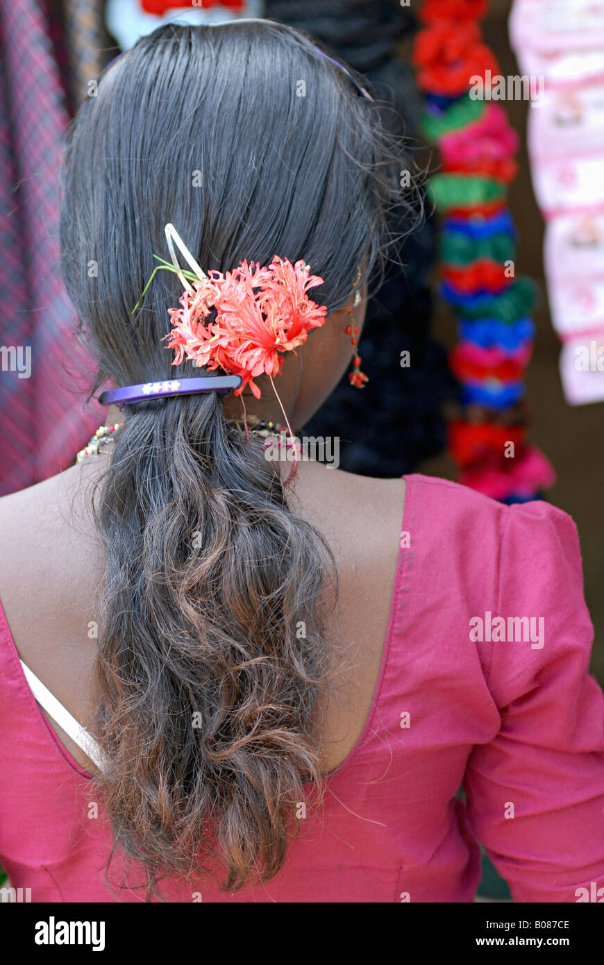 Vue arrière de la tribu warli girl itinérance sur le marché (HASM) fleurs caché dans ses cheveux Banque D'Images